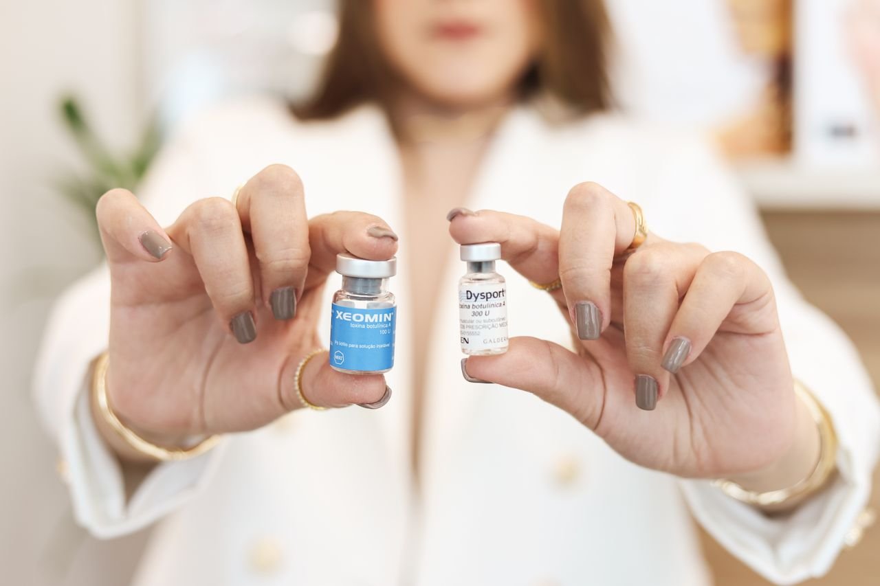 services-03 A close-up of a woman holding Xeomin and Dysport vials, showcasing cosmetic treatment options.